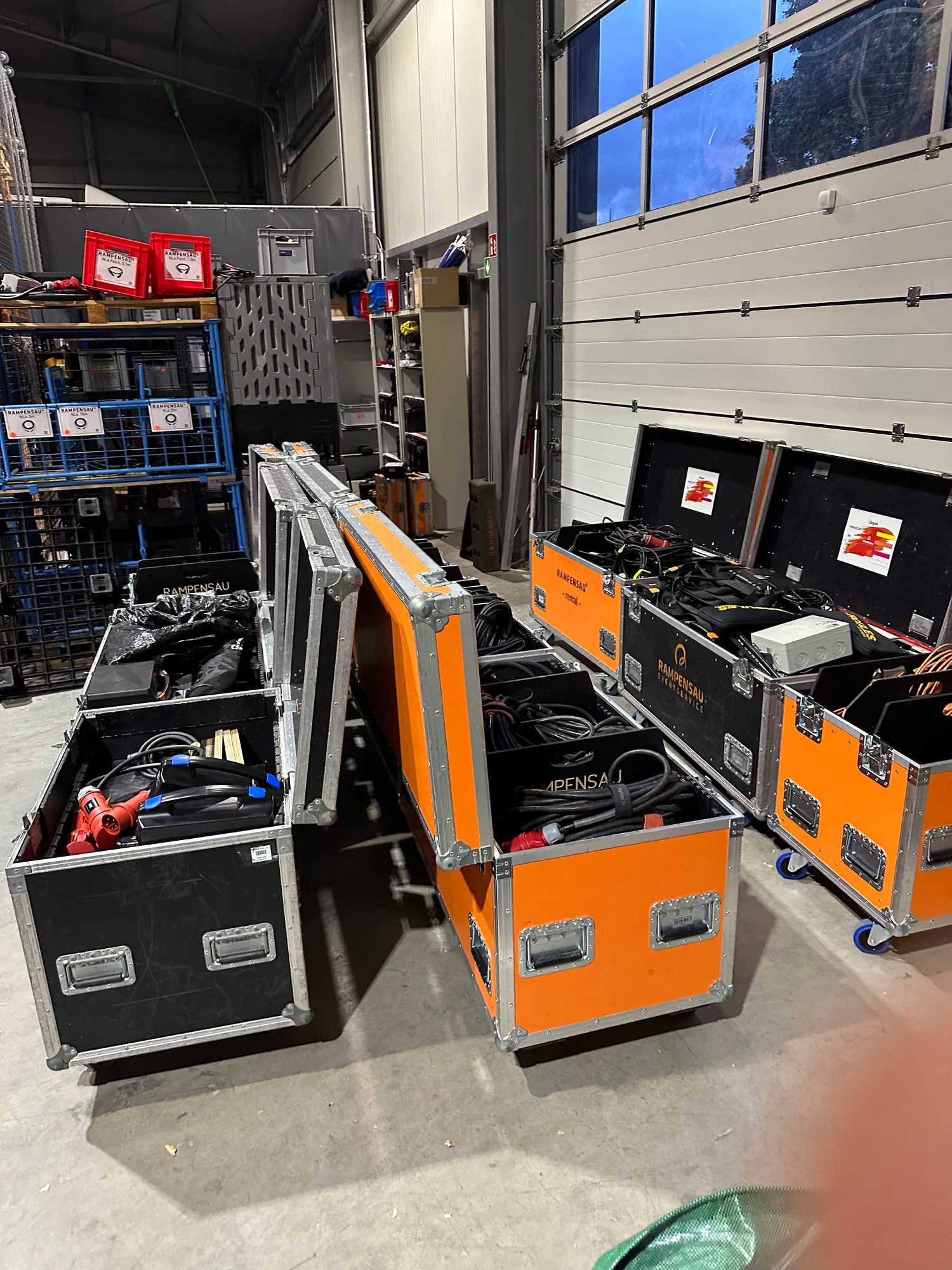 Gepackte orange Flightcases mit Veranstaltungstechnik im Lager von RAMPENSAU in Schwerte